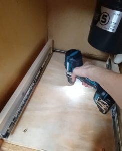 screwing the base in to the sink cabinet